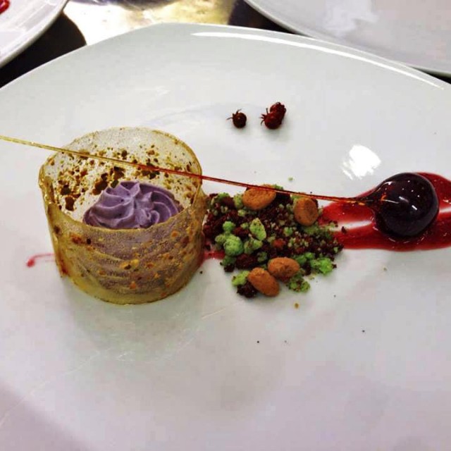 Mousse de mora, tierra de chocolate y pistacho, cereza caramelada